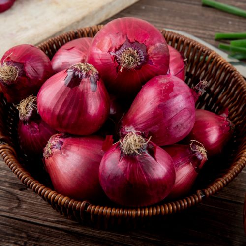 side-view-basket-full-red-onions-wooden-background